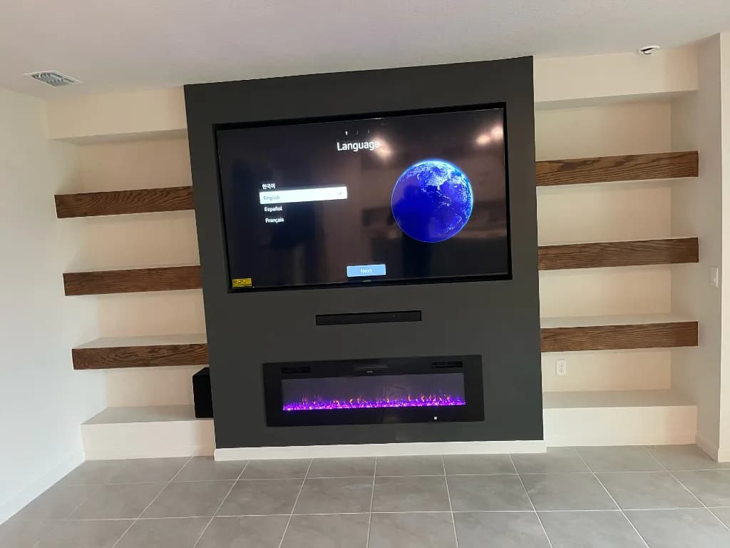 Finished charcoal media wall with an electric fireplace and wood shelves