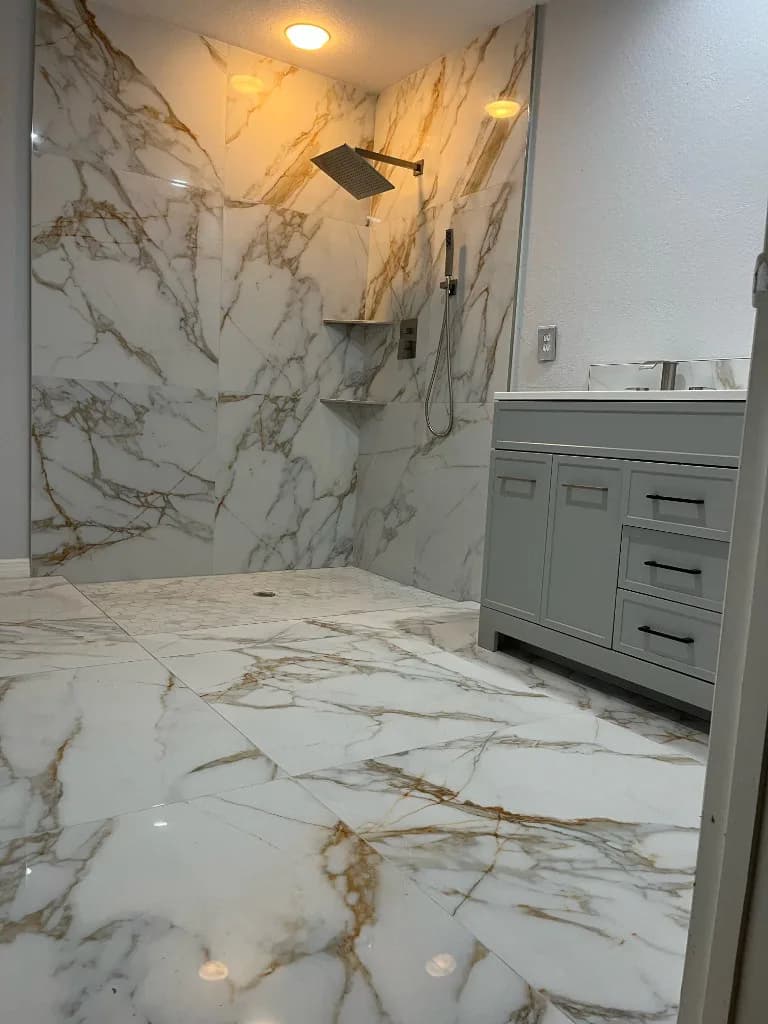 Finished bathroom with gold-veined tile and a gray vanity